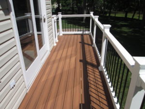This balcony is built of Trex Tiki Torch with a white railing and black metal tube spindles on a home in Perkasie, PA.