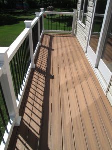 A Trex deck with balcony, white railings and round black metal balusters built in Perkasie, PA.