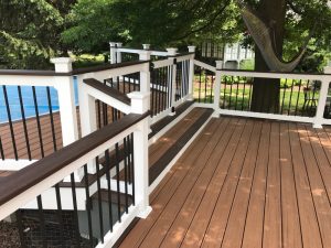 A Trex Transcends two tone deck with cocktail rail, steps leading to a pool and a safety gate built in Quakertown, PA.