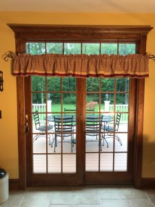 We installed this Andersen sliding French door, stained, with transom, grills and custom trim including header crown molding.