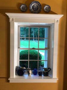 In Quakertown we finished a deep sill painted window with custom made trim with rosettes and crown molding header