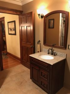 A remodeled bathroom with a Cherry vanity with granite counter top with oiled bronze fixtures in Quakertown.