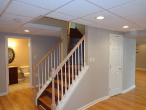 A finished basement with an oak stair case leading to the rest of this home in Doylestown, PA.