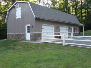 We built this A Gambrel roof style detached garage with stone work to blend in with the home in Quakertown, PA.