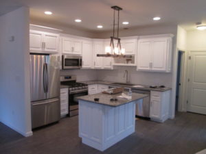 Kitchen renovation - White enamel finish cabinets with granite counter top with laminate rustic grey  flooring in Sellersville, PA.