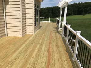 A pressure treated deck with white vinyl railing and pergola we built in A Riegelsville, PA.