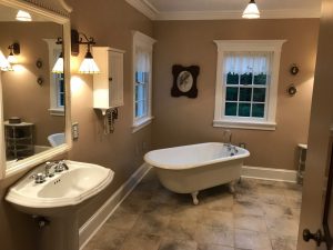We remodeled this antique design master bathroom with claw foot tub,pedestal sink with porcelain tile and custom trim & crown molding.